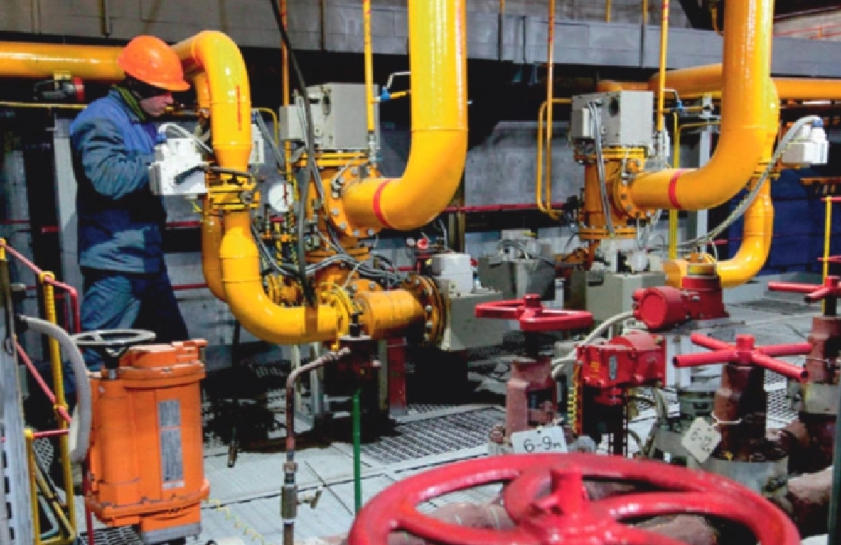 Зауыттағы жұмысшы сары құбырлар мен қызыл клапандарды тексереді. - МЭКС