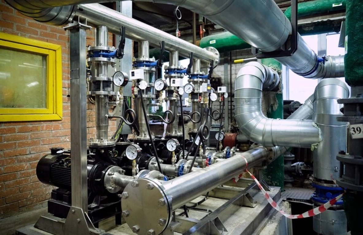 Here's a concise alt text description:

> Industrial piping system with multiple pumps and gauges. - МЭКС